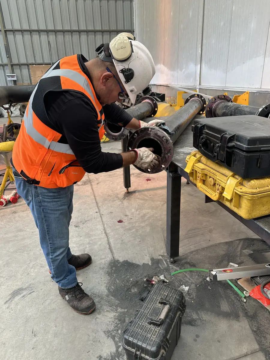 Técnico ajustando una brida en un tramo de cañería
