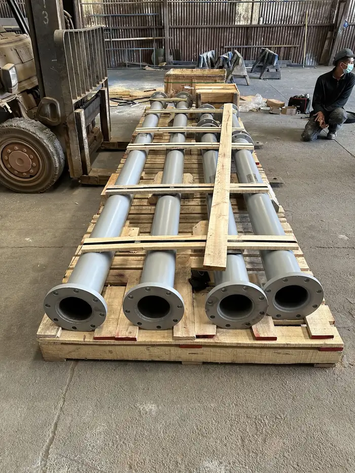 Tramos rectos de cañería pintada alineados sobre pallet